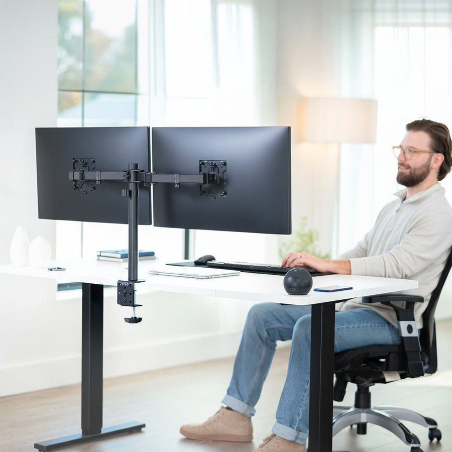 Person working at a desk with two monitors on a VIVO dual monitor mount